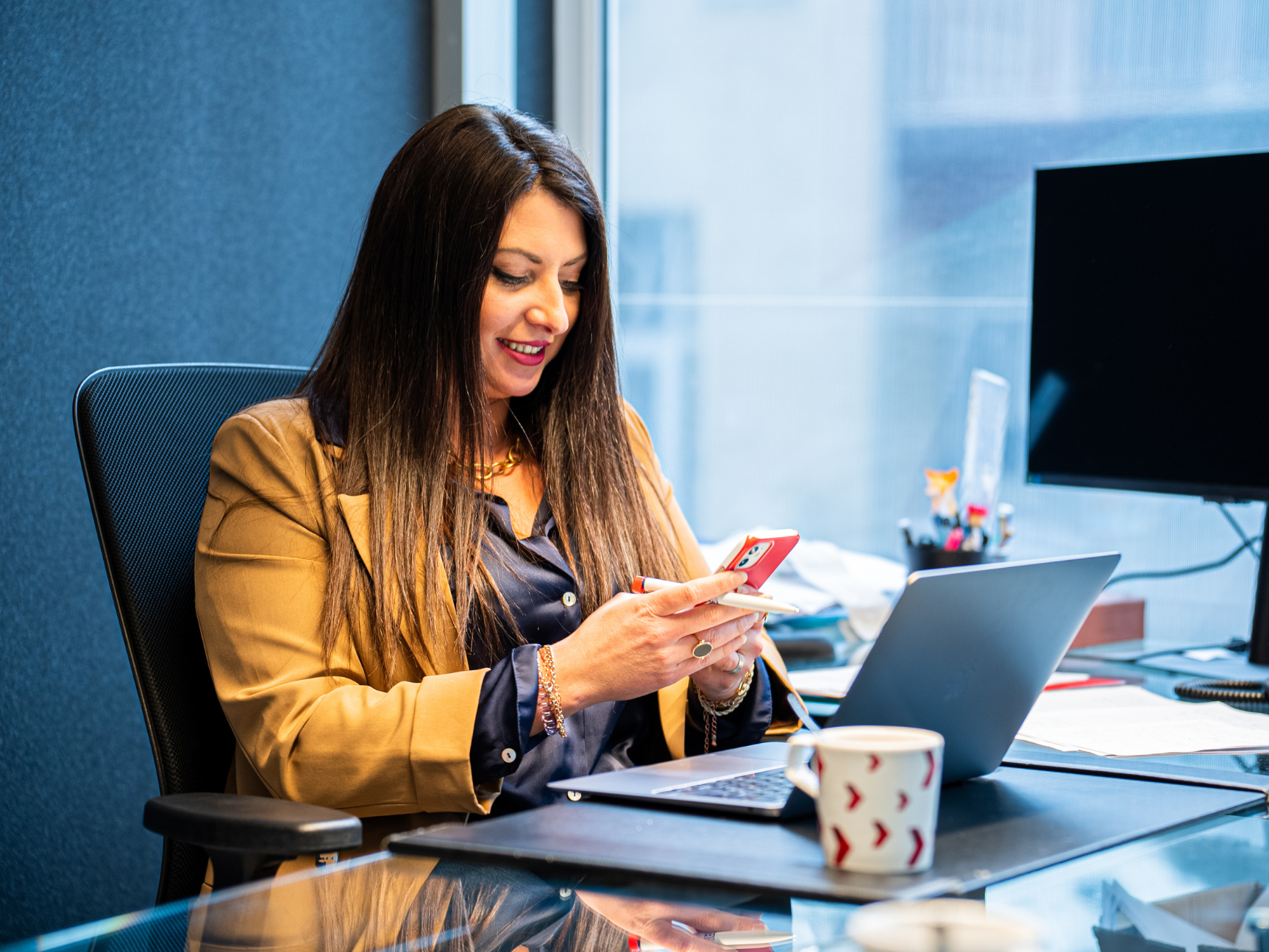 Broker on her mobile phone at a desk.