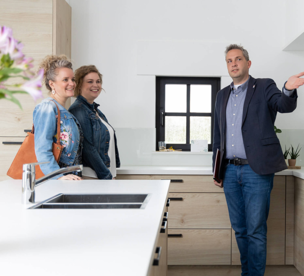 Man leidt twee vrouwen rond in het huis.