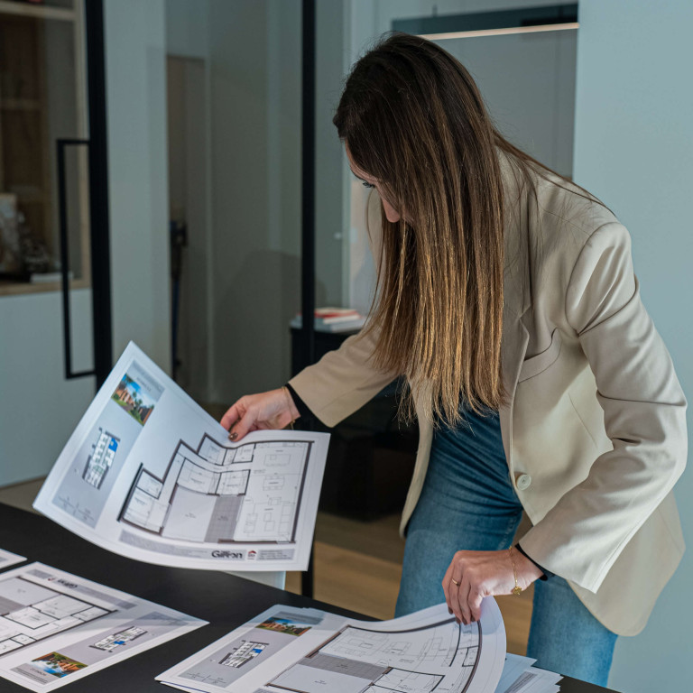 Een vrouw bekijkt bouwplannen van een woning.
