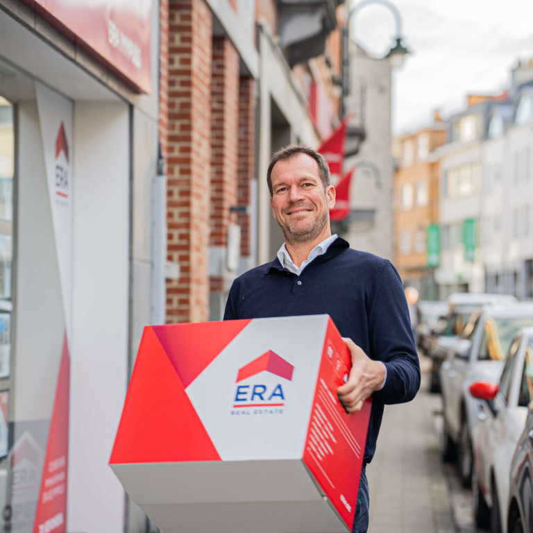 Een man draagt een ERA verhuisdoos.