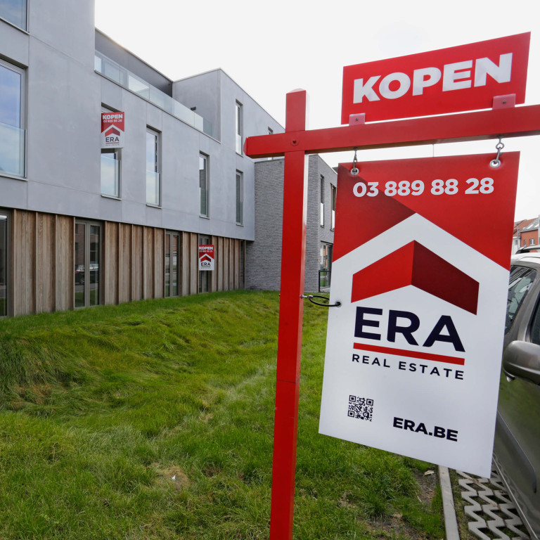 Een appartementsblok dat vol ERA verkoopborden staat.