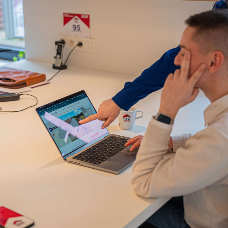Twee personen bekijken een pand op de ERA website.