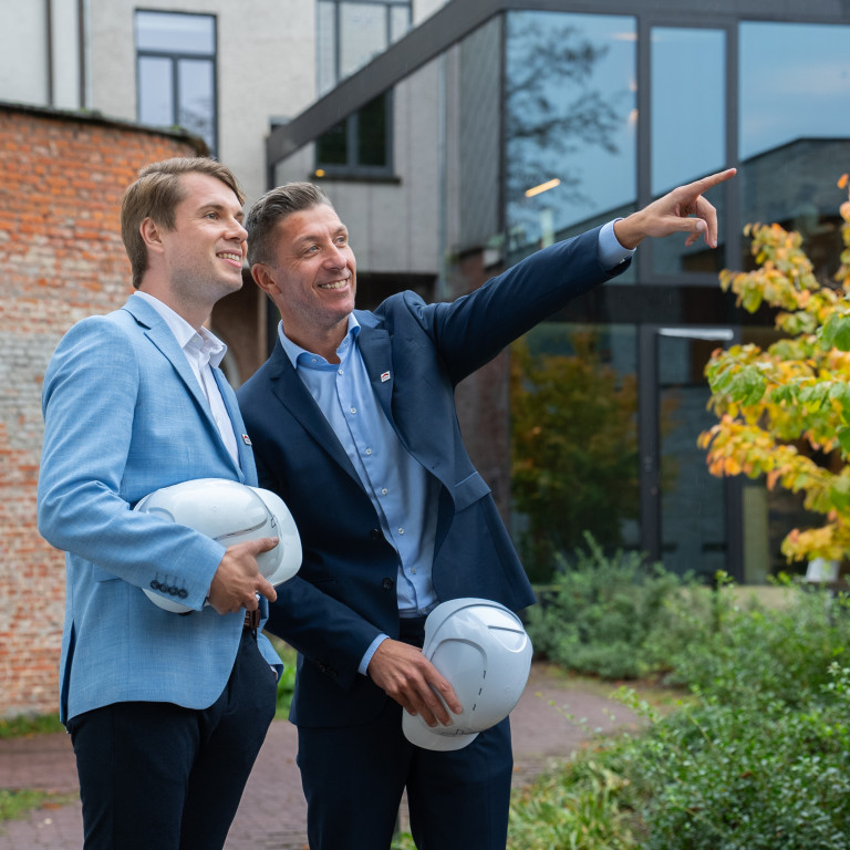 Twee makelaars kijken naar een nieuwbouwproject