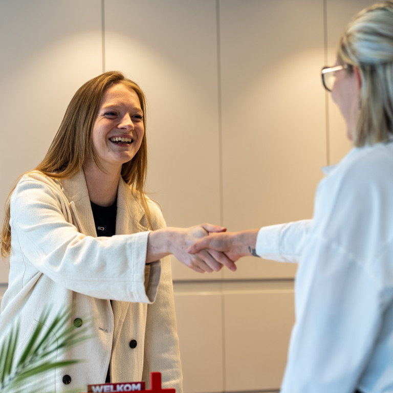 Femme serrant la main d’un client.