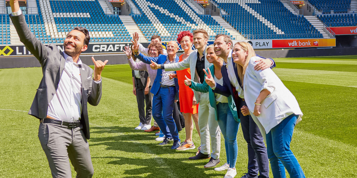 Alle Topmakelaars poseren samen voor een selfie.