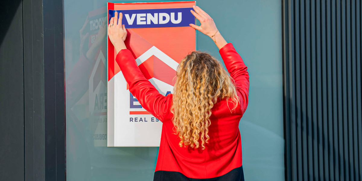 Un agent ERA appose un autocollant portant le mot "vendu" sur un panneau de vente.