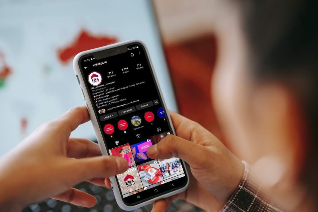 Iemand bekijkt de social media van ERA BELGIUM op zijn gsm.