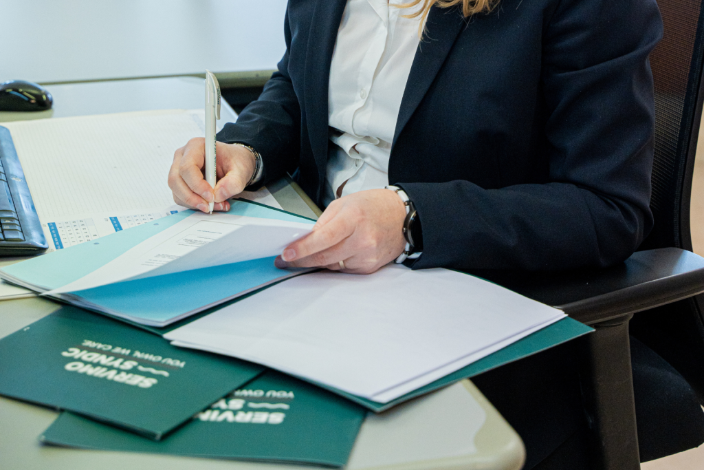 Een syndicus aan een bureau met dossiers.