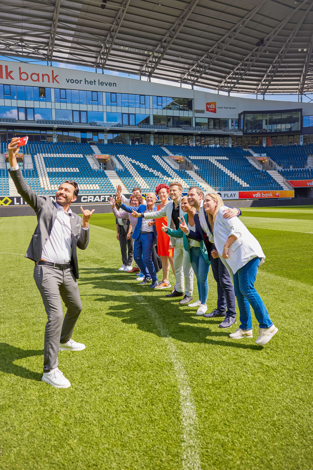 Alle Topmakelaars poseren samen voor een selfie.