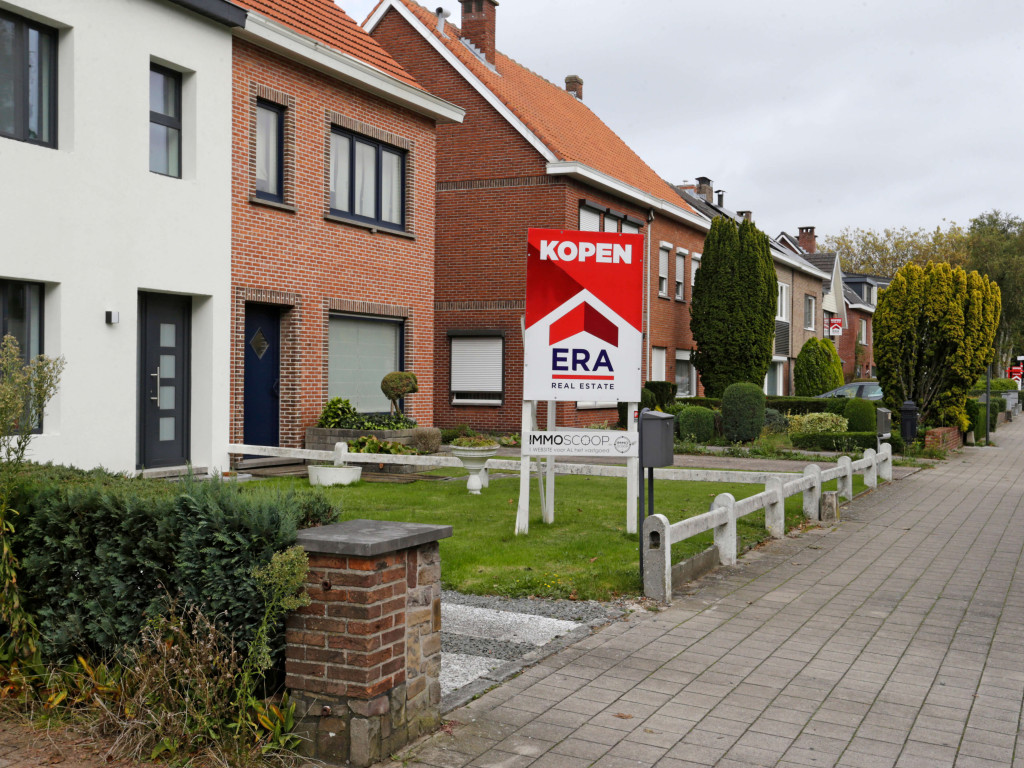 Er staat een groot rood V-bord in de voortuin van een woning dat verkocht wordt via ERA.