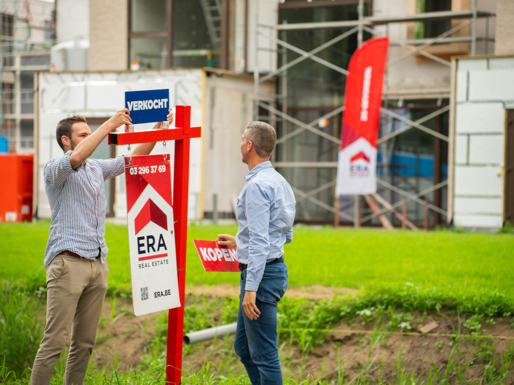ERA makelaar plaatst verkocht bord op tuinpaal voor een nieuwbouwproject.