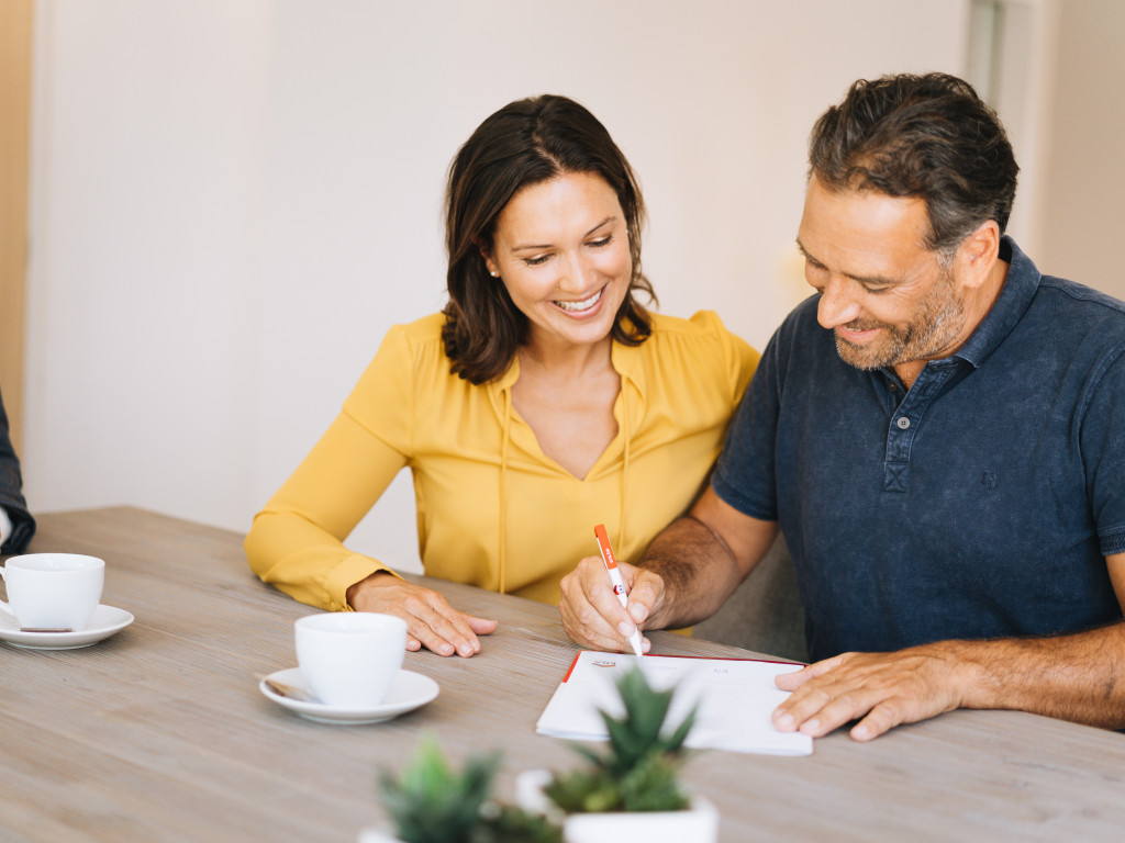 man en vrouw tekenen een optie voor een woning