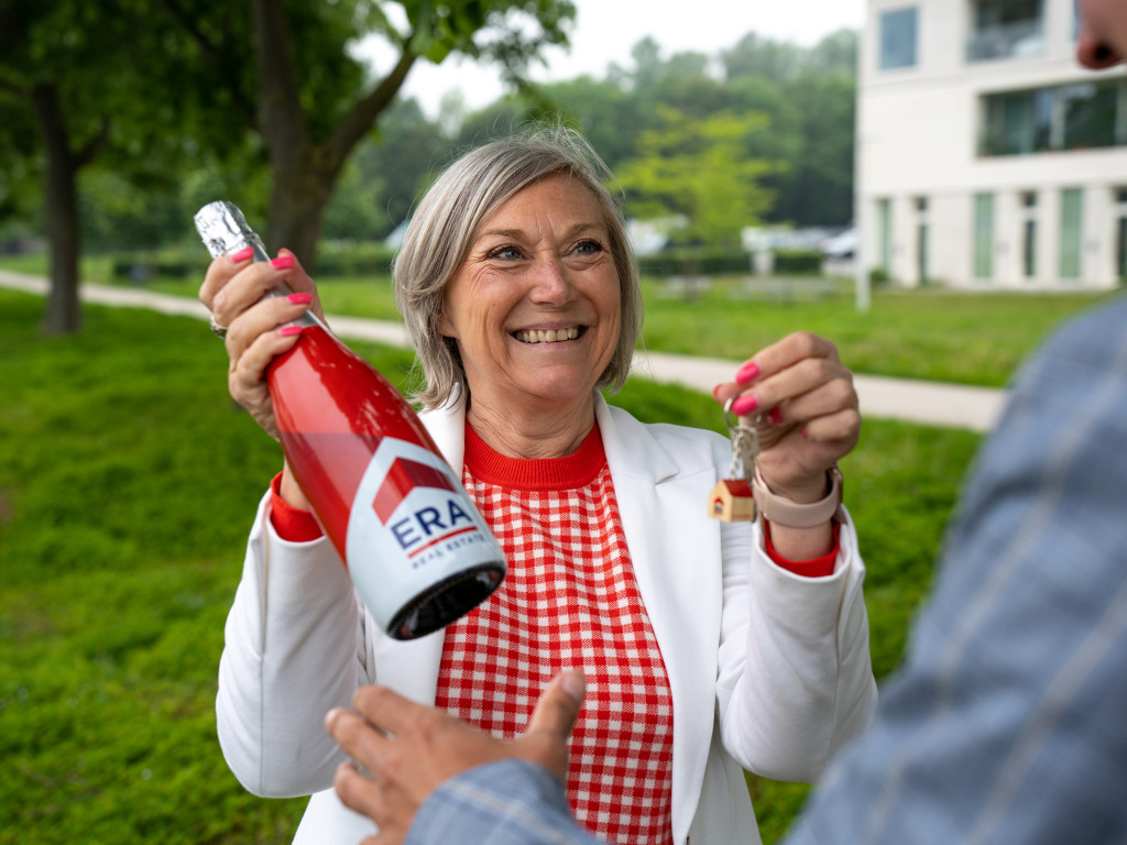 L'agent immobilier donne les clés et du champagne à l'acheteur