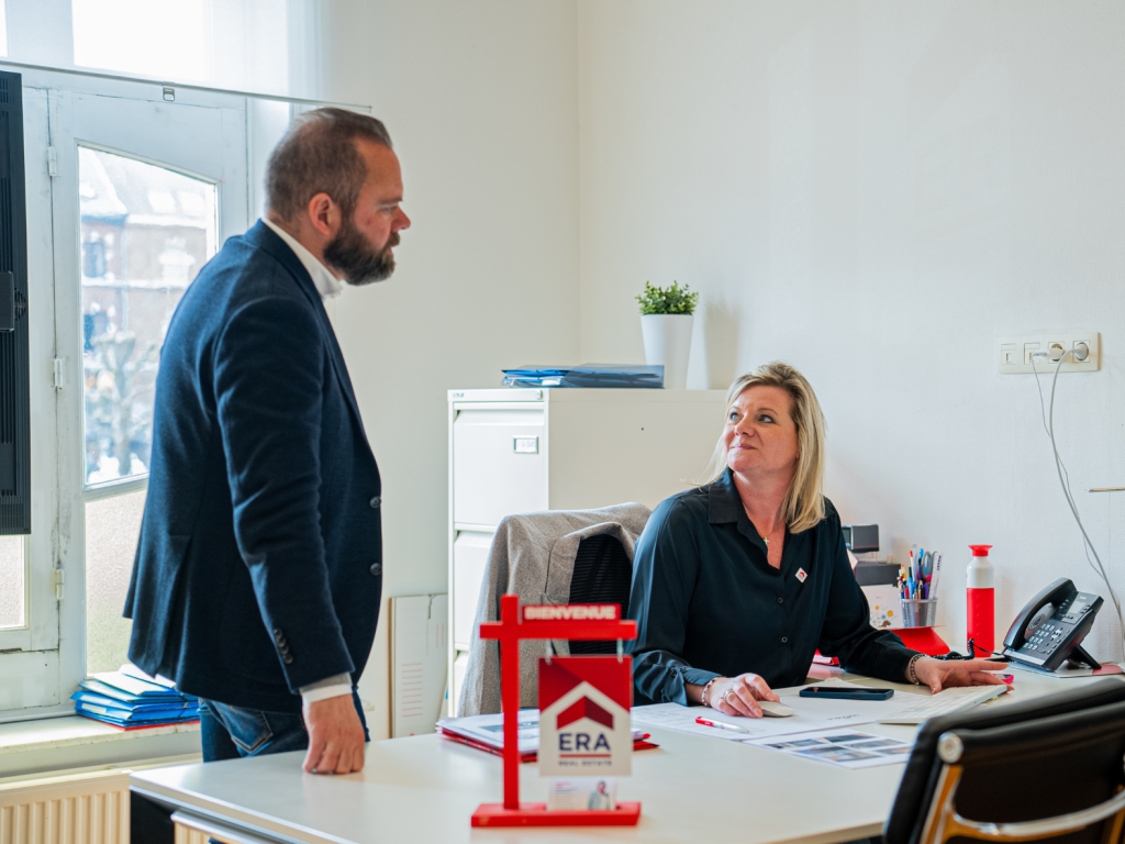 Twee makelaars aan een bureau.