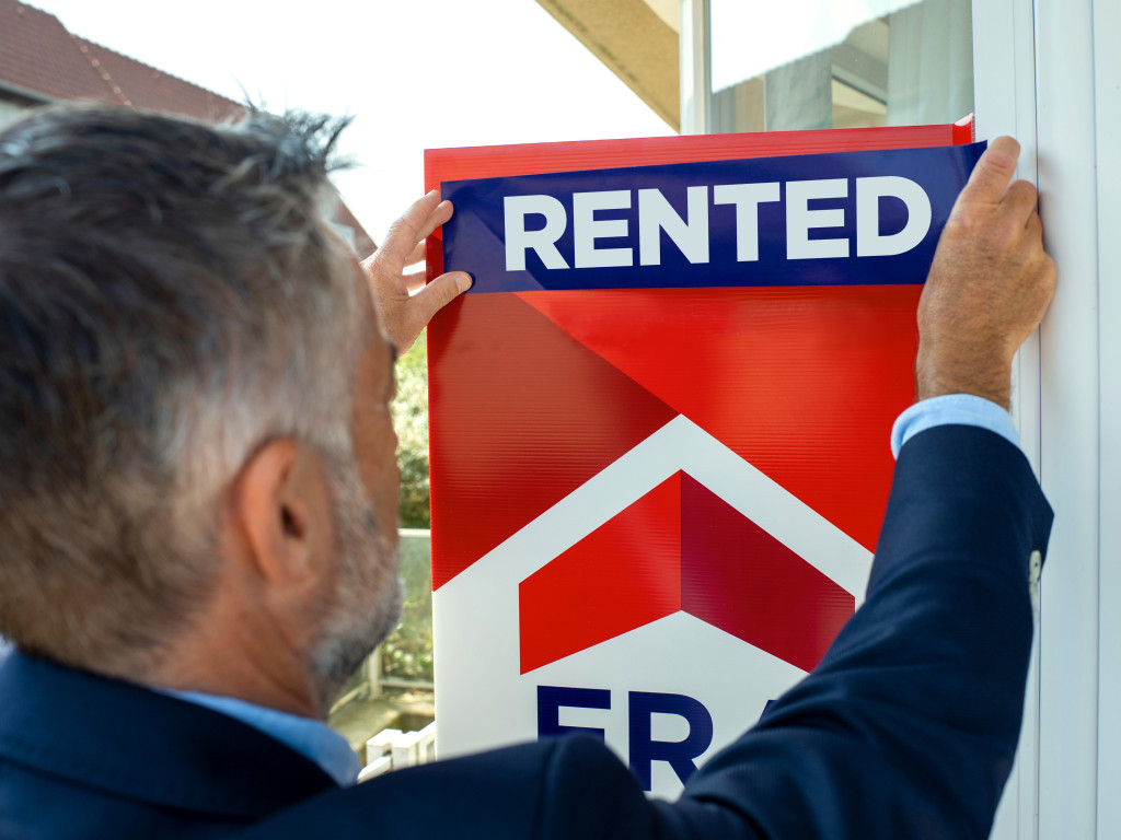 The real estate agent puts rented on the sign