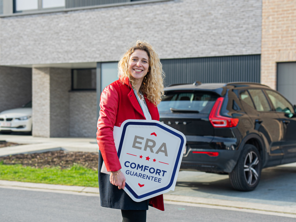 An ERA broker holds an ERA Comfort Guarantee V-Board.