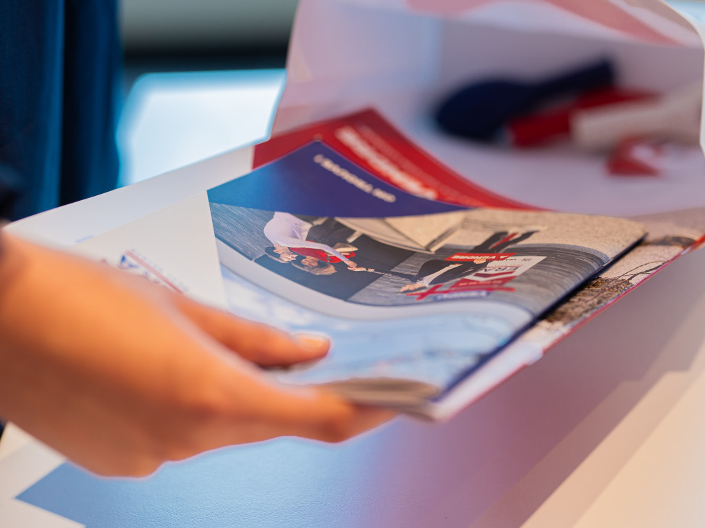 Een persoon vult een goodiebag met ERA Open Huizen Dag materiaal.