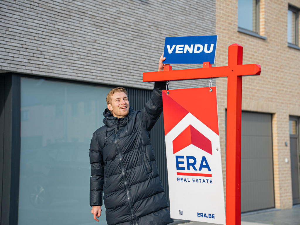 Agent immobilier ERA avec un panneau vendu