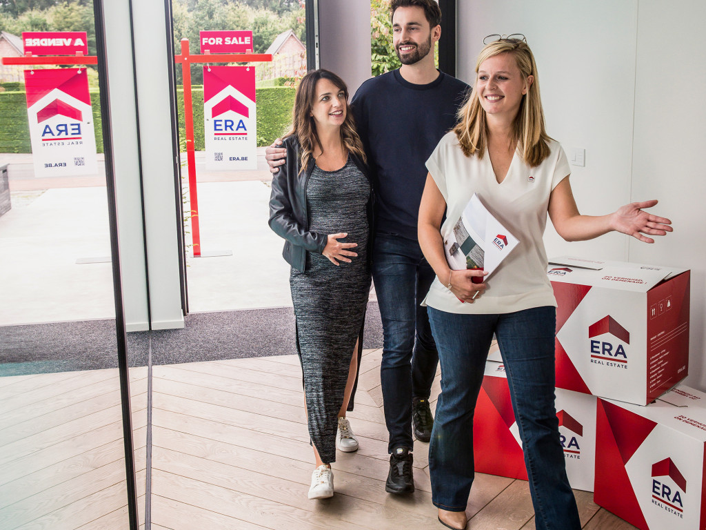 An ERA estate agent shows a couple around a property for sale.