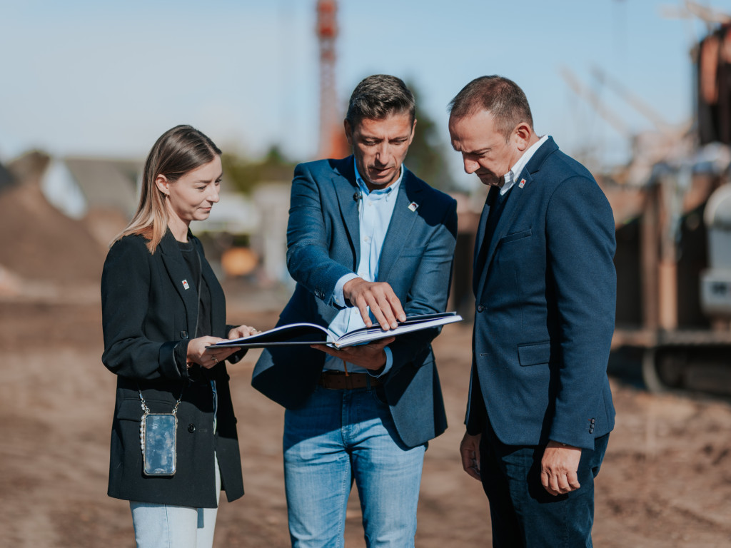 2 makelaars en 1 verkoper omtrent de bouwgrond met plannen