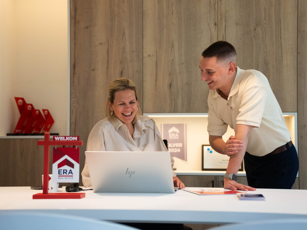 2 makelaars rond een plan op de laptop