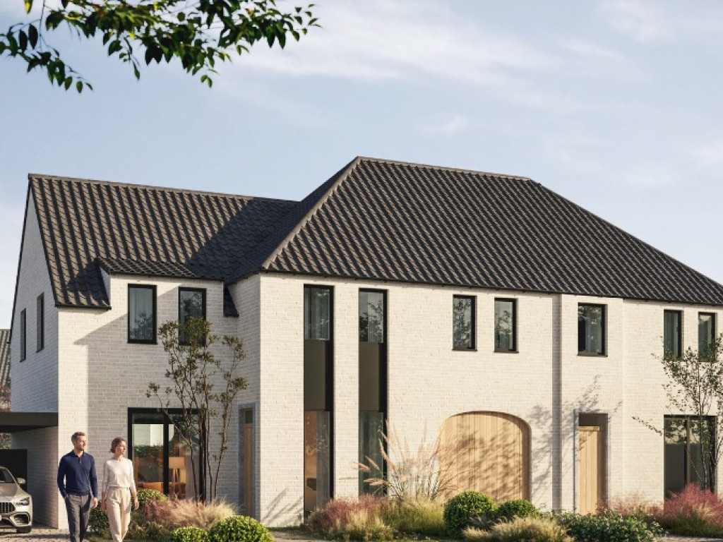 Koppel wandelt langs een nieuwe witte woning met donker pannendak en carport