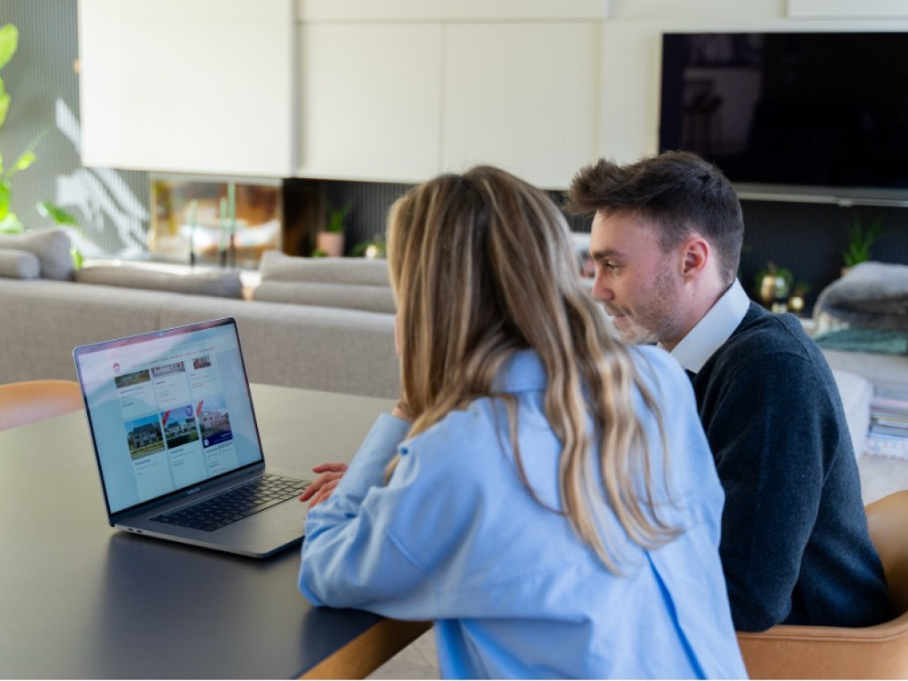 Koppel zoekt samen naar een eerste woning op de laptop