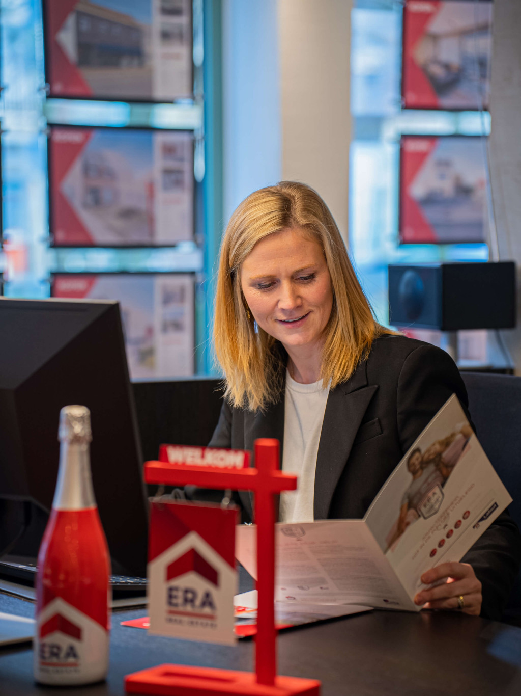 Een ERA makelaar aan haar bureau.