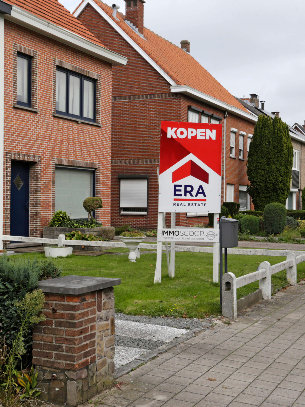 Er staat een groot rood V-bord in de voortuin van een woning dat verkocht wordt via ERA.