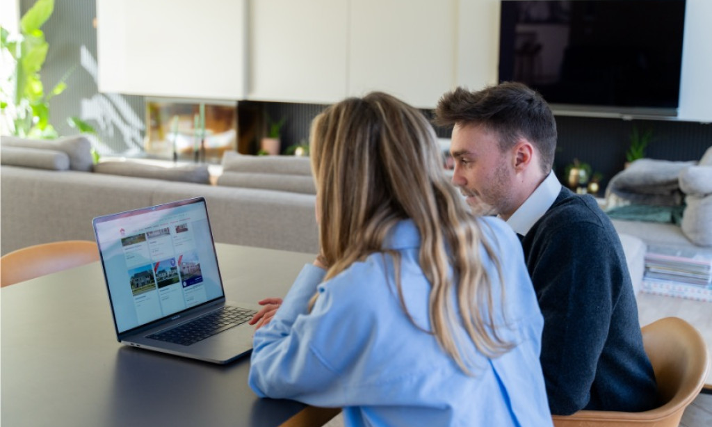 Koppel zoekt samen naar een eerste woning op de laptop