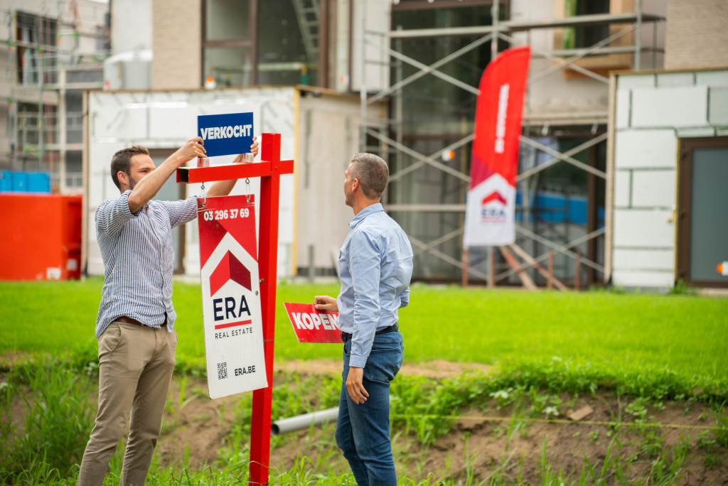 ERA makelaar plaatst verkocht bord op tuinpaal voor een nieuwbouwproject.